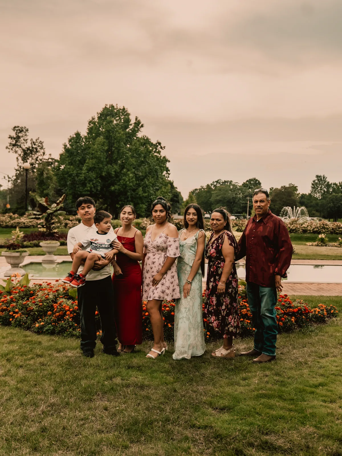 The family standing together in front of a flower garden