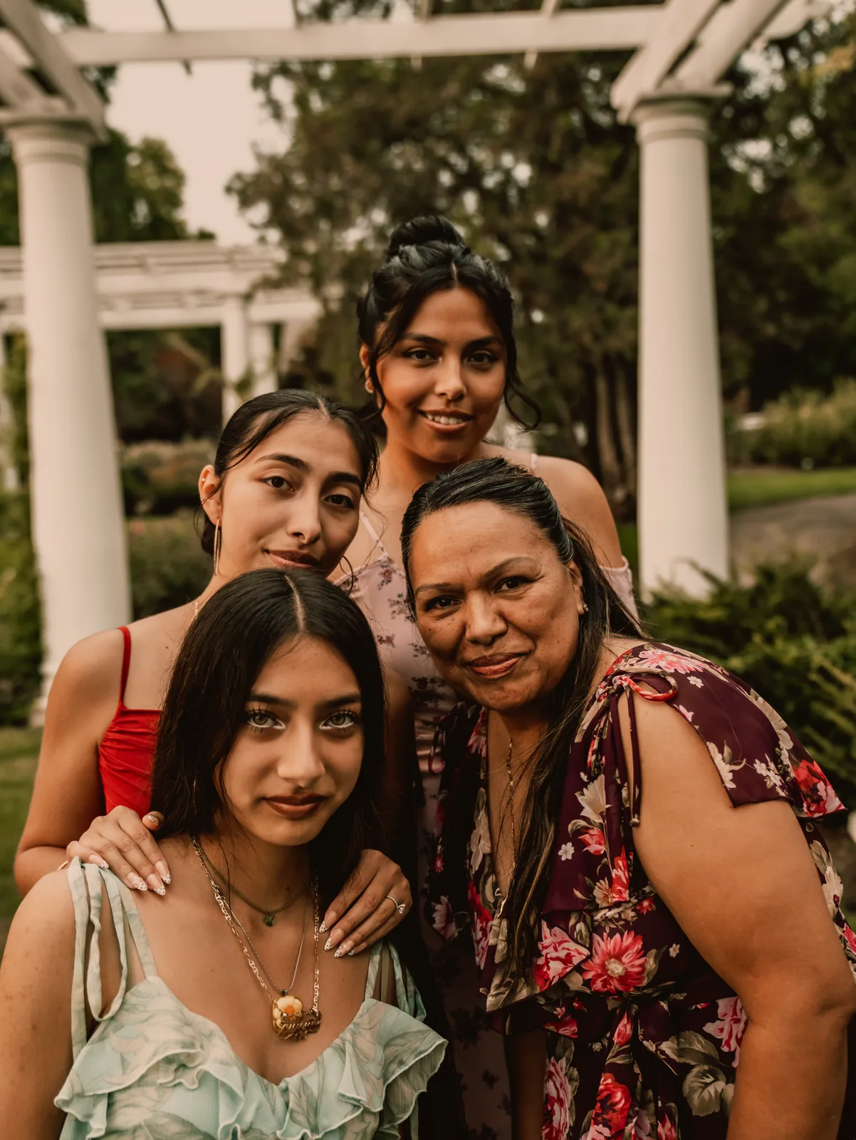 A mother holding her daughters close, all smiling