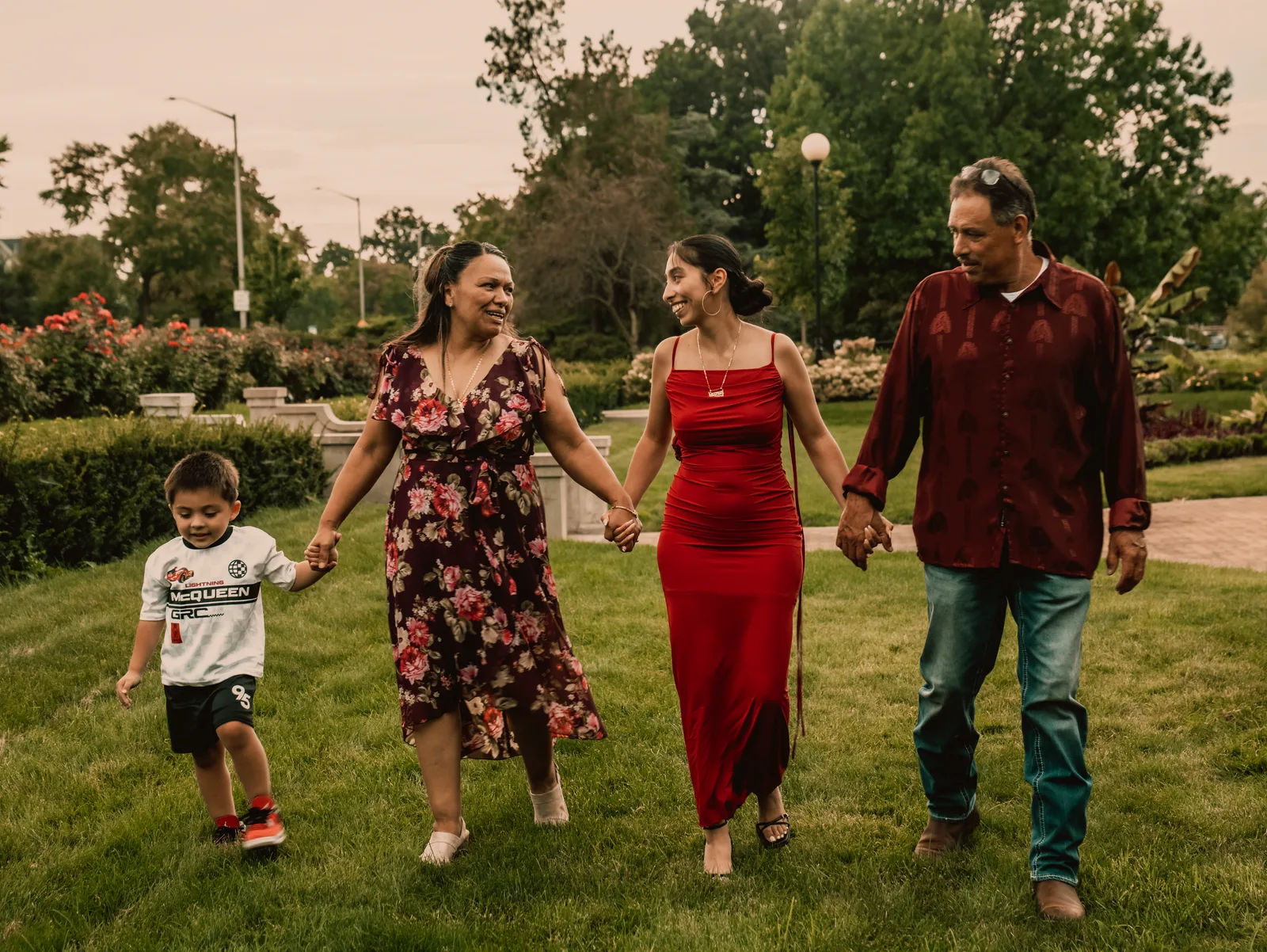 The family walking hand in hand across the lawn