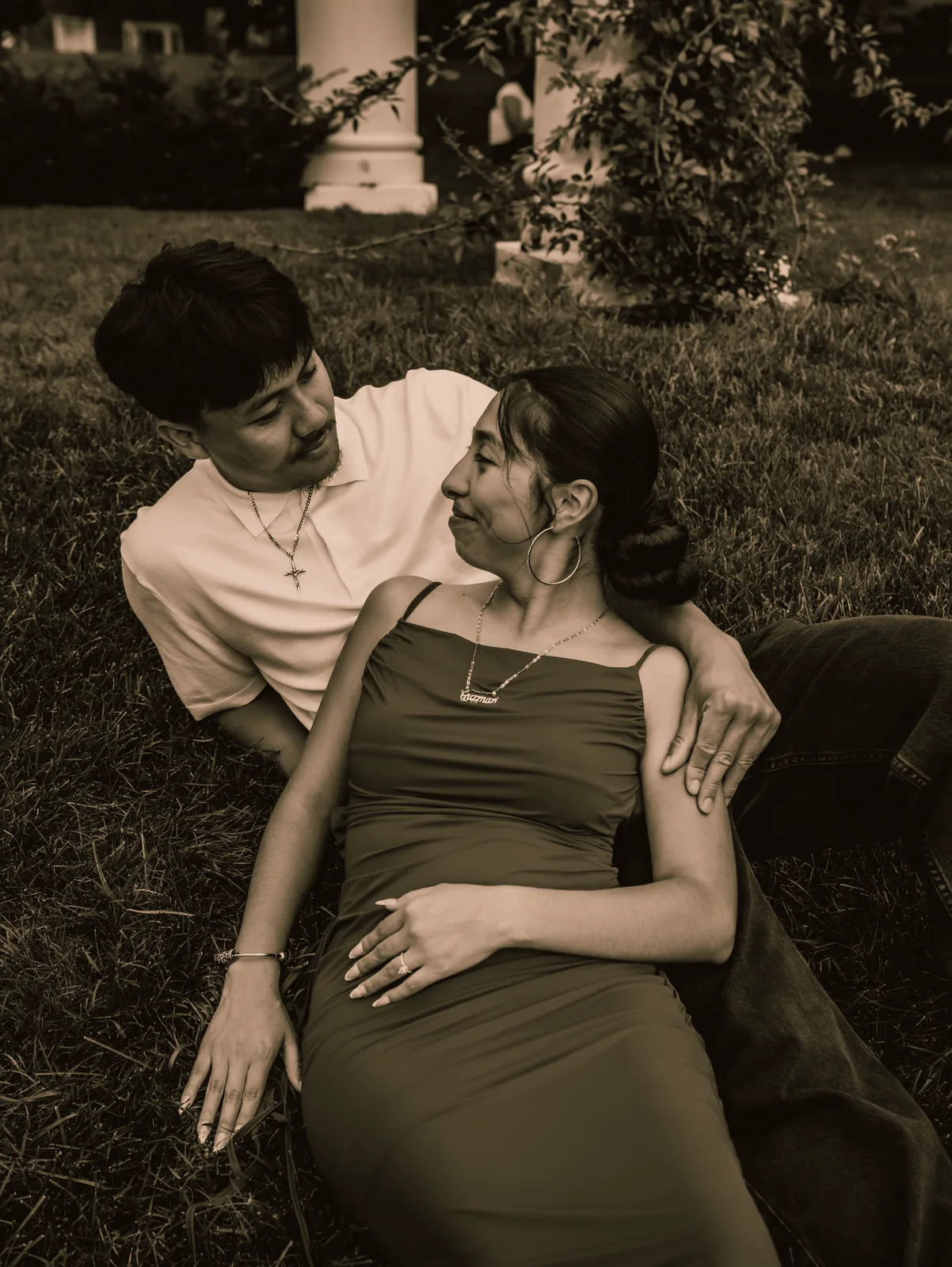 The couple leaning close together in the grass