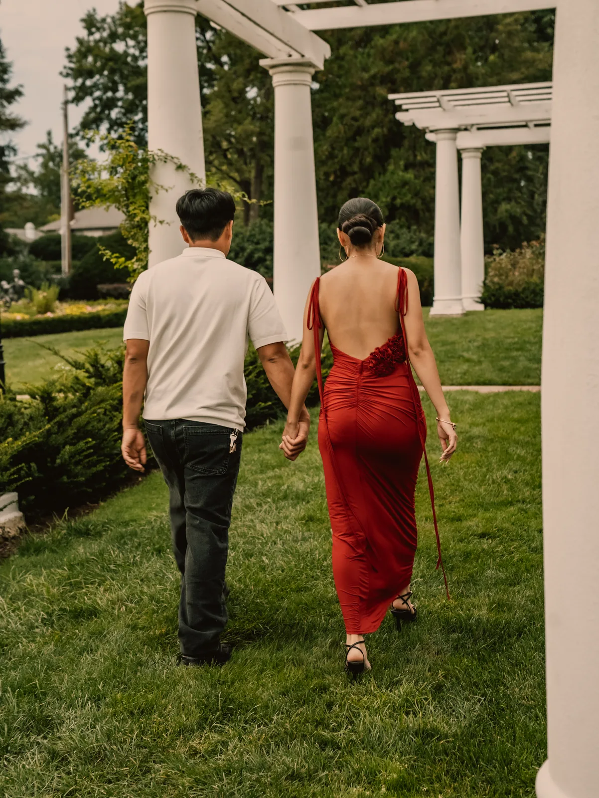 The couple walking away through the garden together