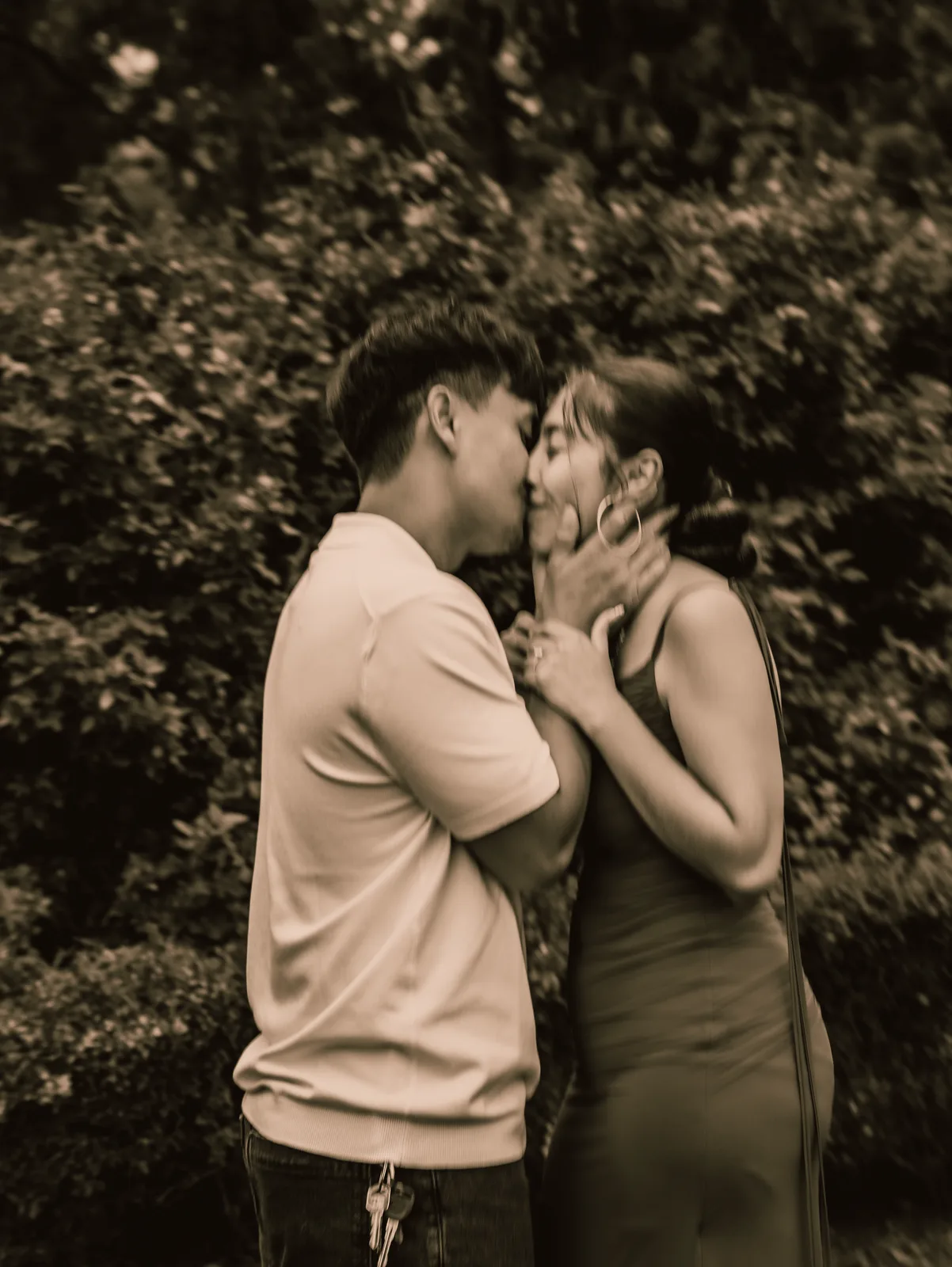 The couple sharing a kiss in the garden, toned